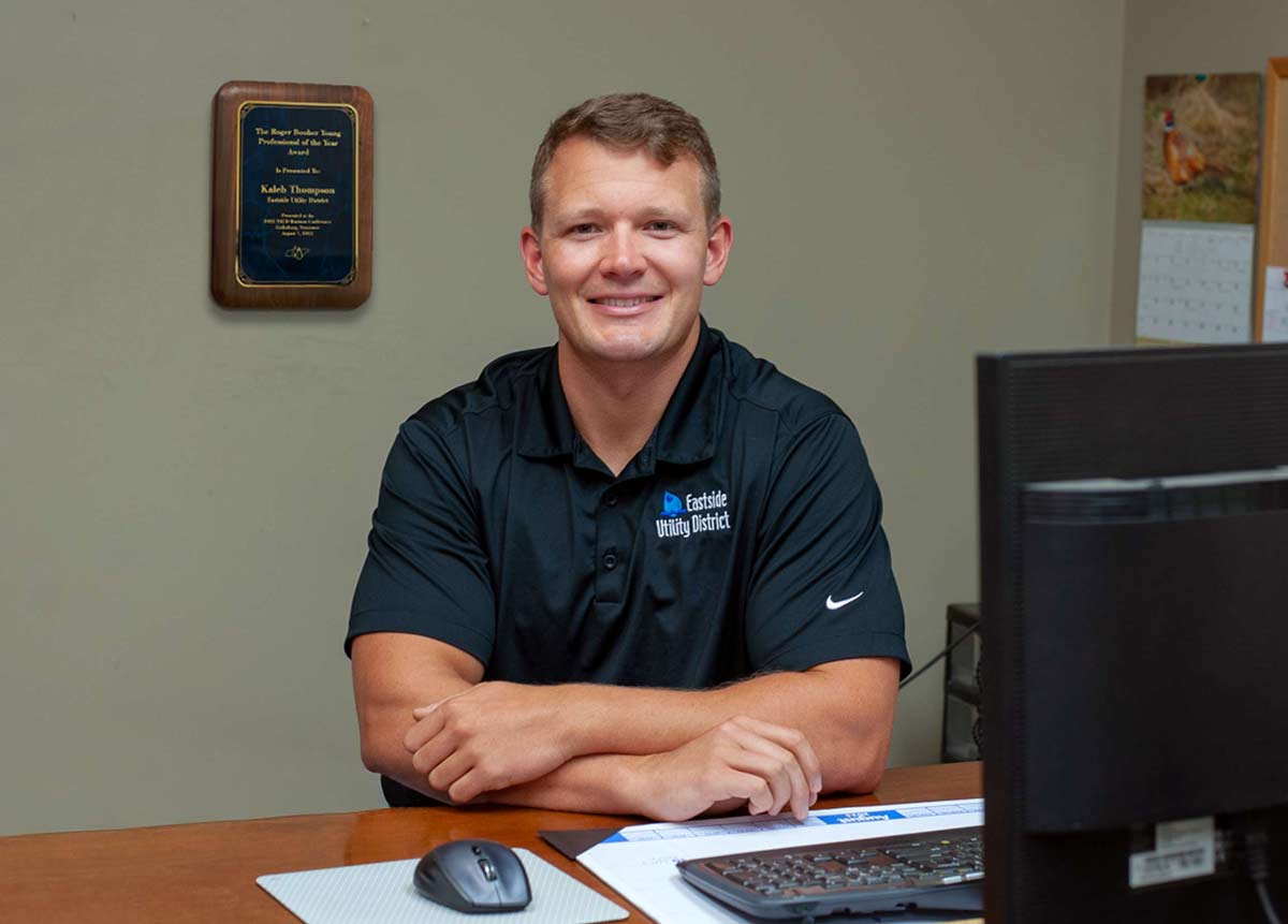 Kaleb Thompson, Staff Engineer, Sitting at his desk at Eastside Utility District